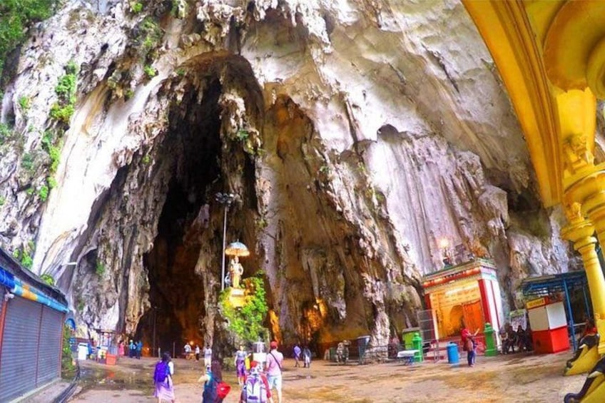 Una cueva con una estatua en su interior, rodeada de visitantes. 5