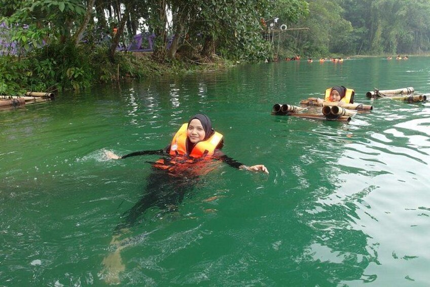 A person floating on a raft in a river surrounded by greenery. 3