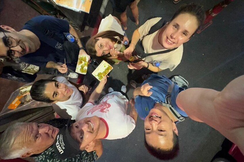 A group of people sitting around a table, eating and drinking. 5