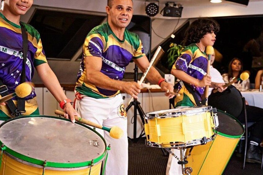 A group of people playing drums in a room. 4