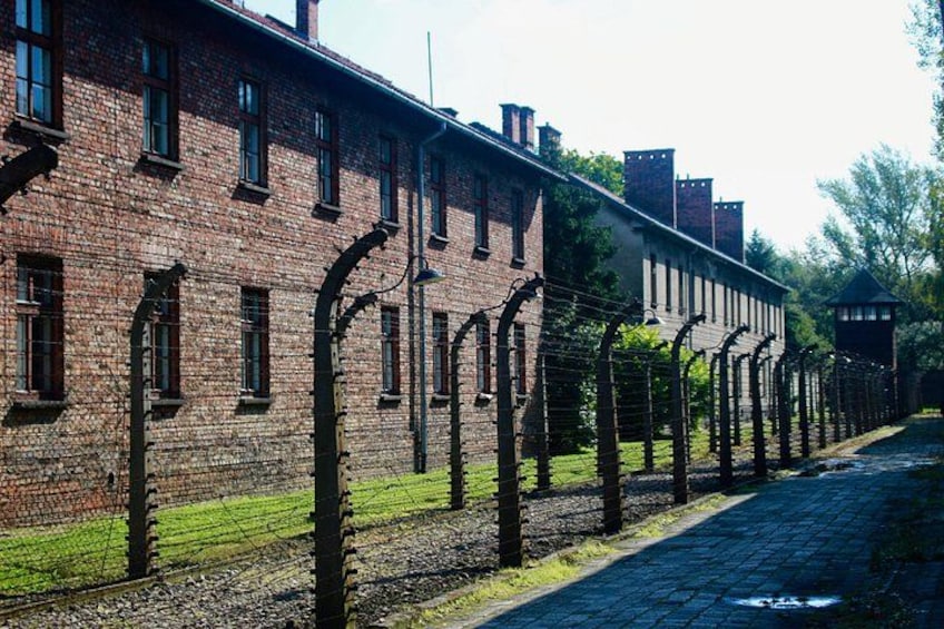 Ein Backsteinhaus mit Stacheldrahtzäunen und einem Kopfsteinpflasterweg. 2