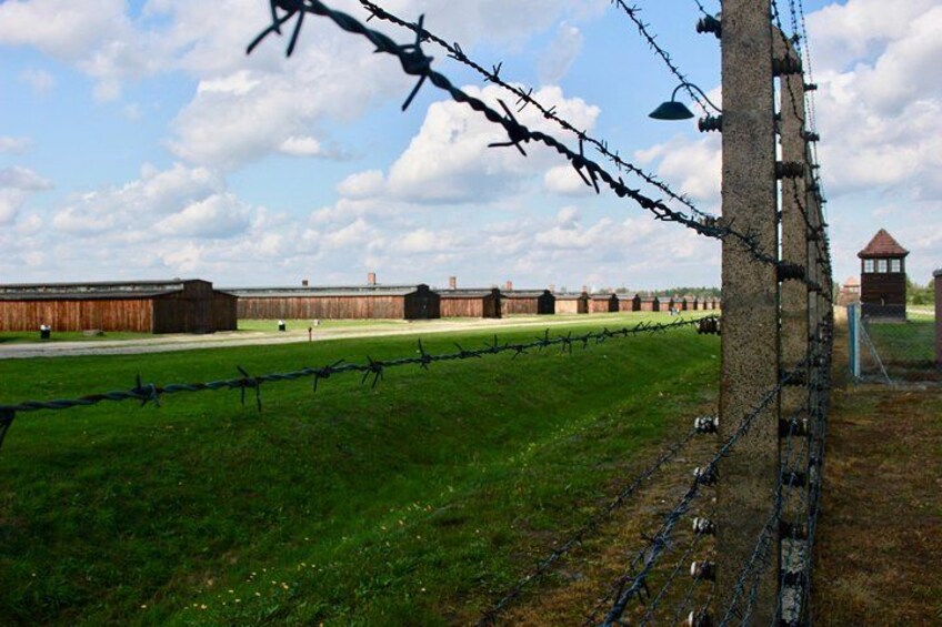 A barbed wire fence, a wooden building, and a clear sky. 3