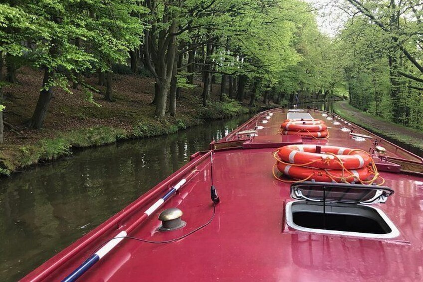 En rød båd med redningskranse på en smal kanal omgivet af træer. 5