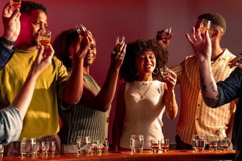 A group of people toasting with drinks at a bar. 5