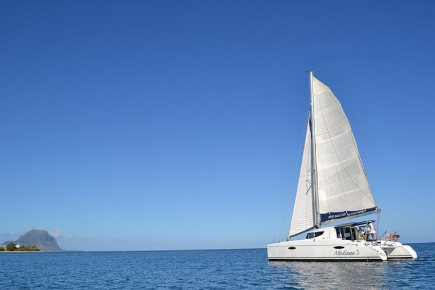 Un voilier à la coque blanche et à la grande voile blanche, naviguant sur une mer calme. 3