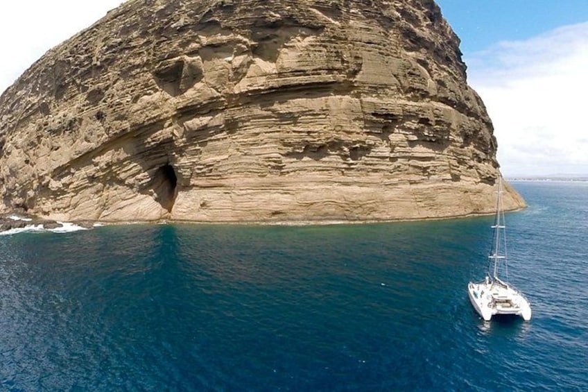 Une grande formation rocheuse avec un bateau sur l’eau. 5