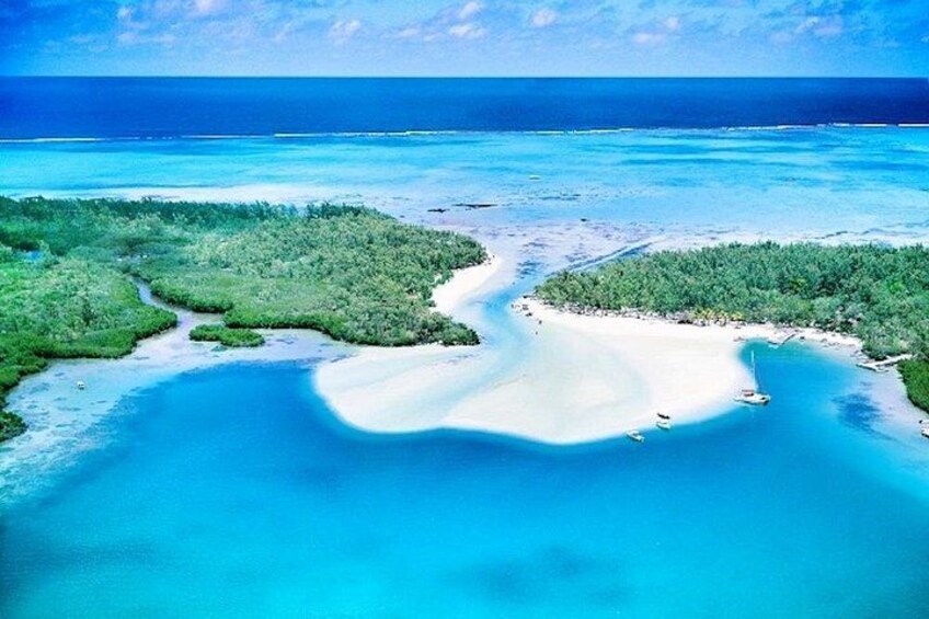 Een turquoise zee, een wit zandstrand en groene begroeiing. 4