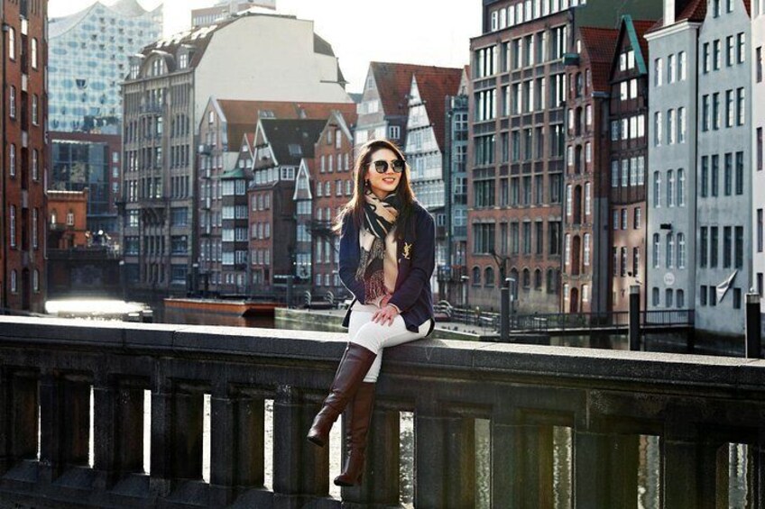 Eine Person sitzt auf einer Brücke mit einer Stadtansicht im Hintergrund. 5