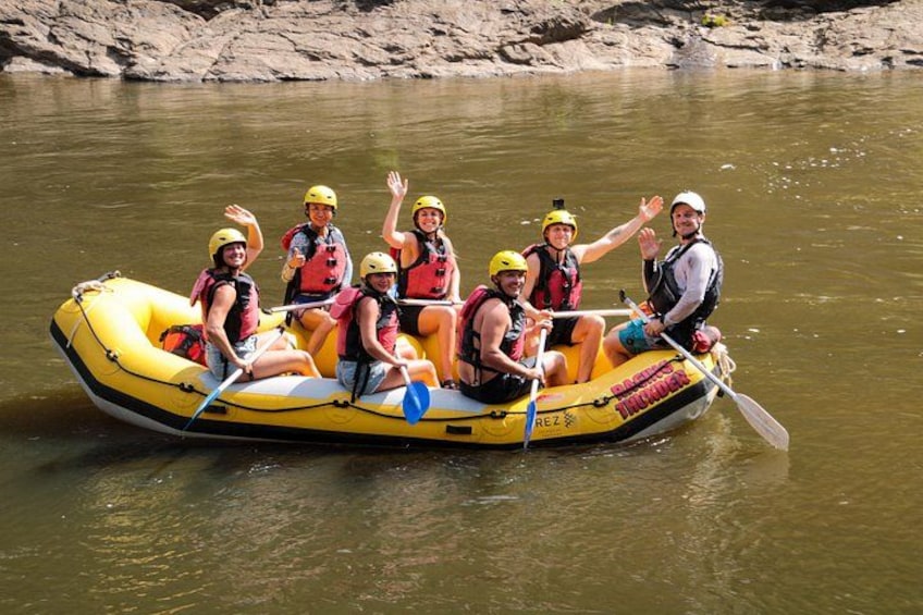 A group of people on a yellow inflatable raft on a river. 2