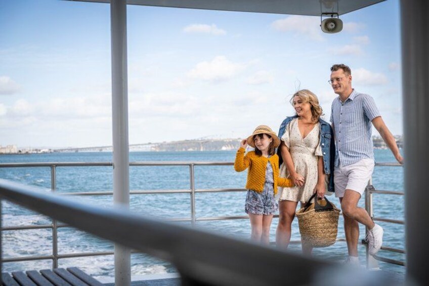 A family on a boat with a view of a bridge and water. 2