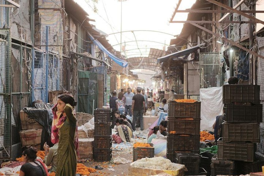 A bustling market with people shopping and vendors selling goods. 4