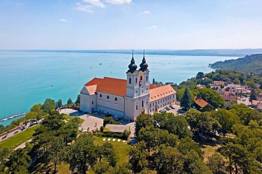 A church with two towers, surrounded by trees and a body of water. 4