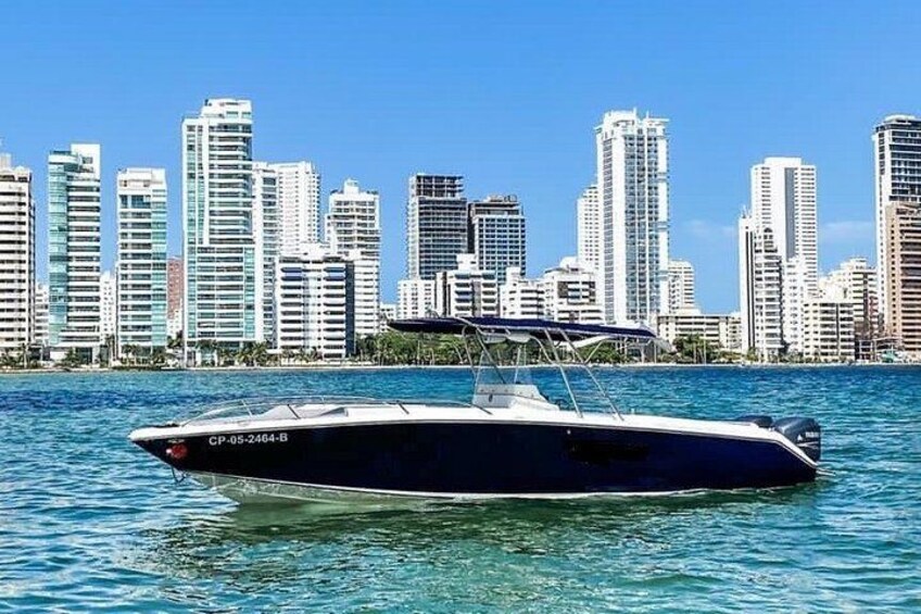 A speedboat on water with a city skyline in the background. 1