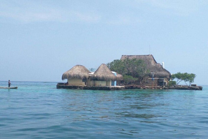 A thatched-roof house on stilts in a calm sea. 4