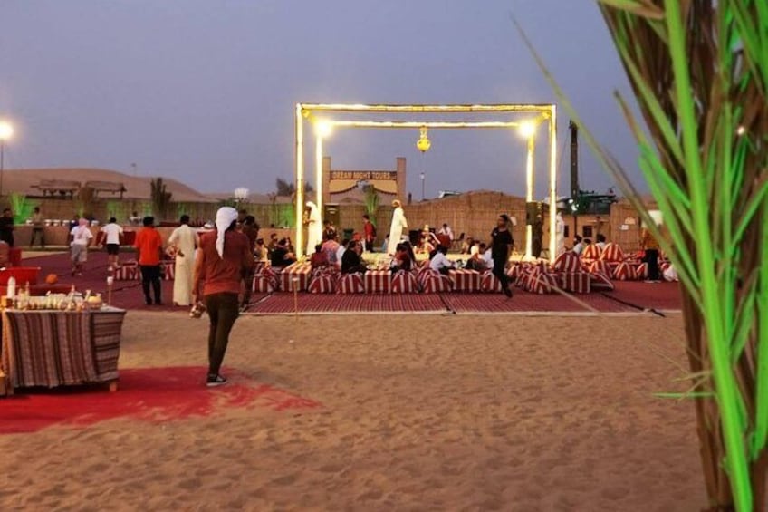 A desert setting with a stage and seating area, possibly for an event or gathering. 5