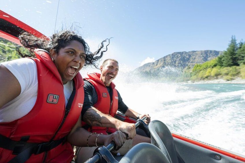 Zwei Personen in roten Rettungswesten auf einem Boot. 3