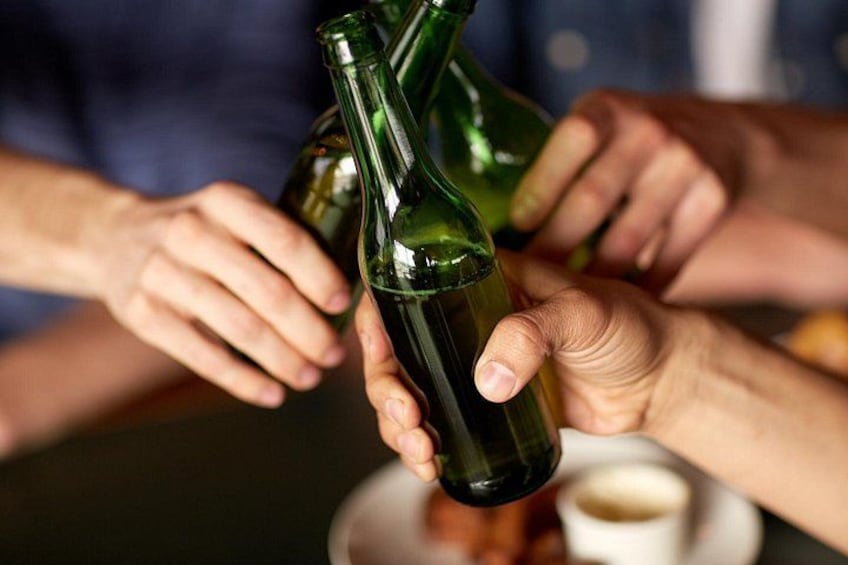 A person holding a green wine bottle. 1