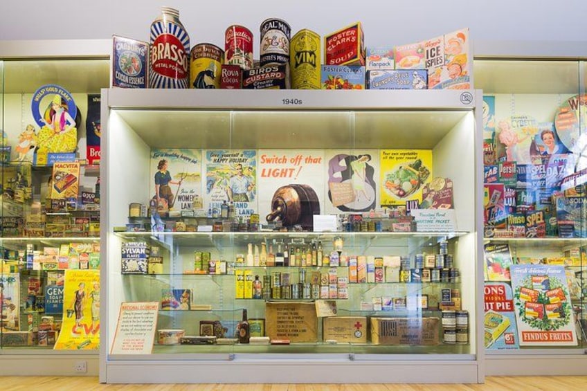 A vintage store display with canned goods, bottles, and vintage advertisements. 2