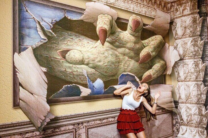 A mural of a large bird with outstretched wings and a woman in a red skirt reacting to it. 3
