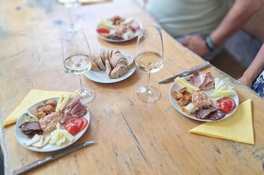 A wooden table with plates of food and wine glasses. 5