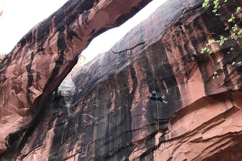 A person climbing a large rock formation. 4