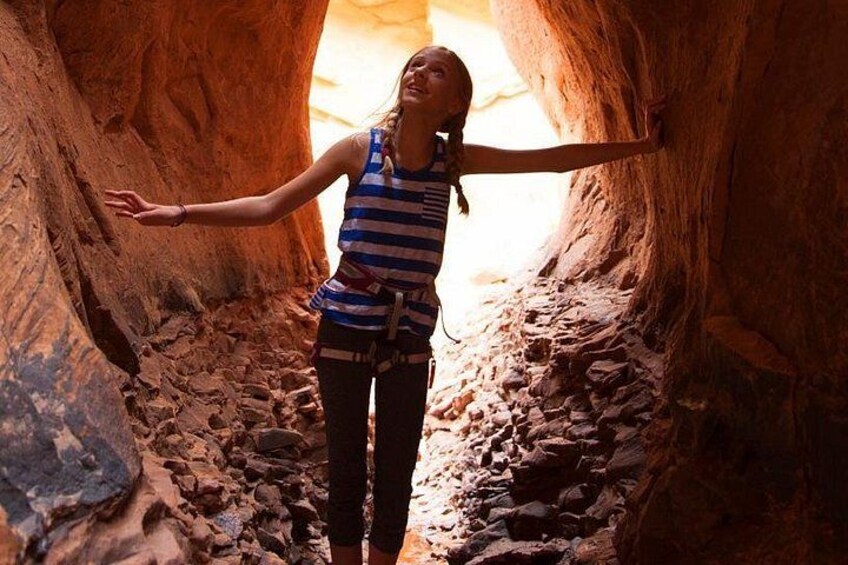 A person standing in a narrow canyon with rocky walls. 2