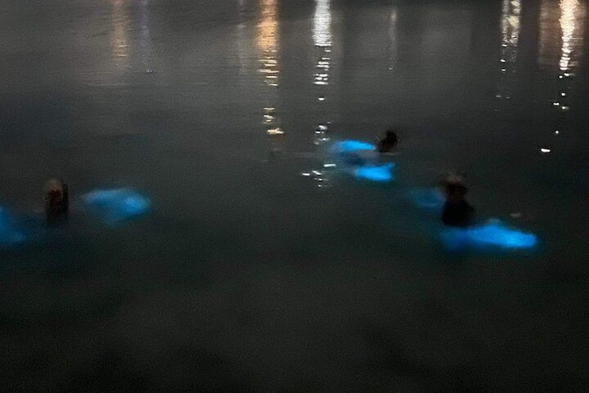 A nighttime scene with people swimming in a body of water. 3