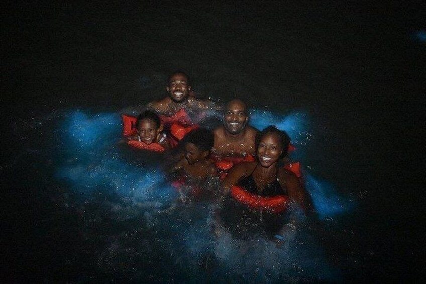 A group of people in a dark environment, possibly a pool, with water splashes around them. 3