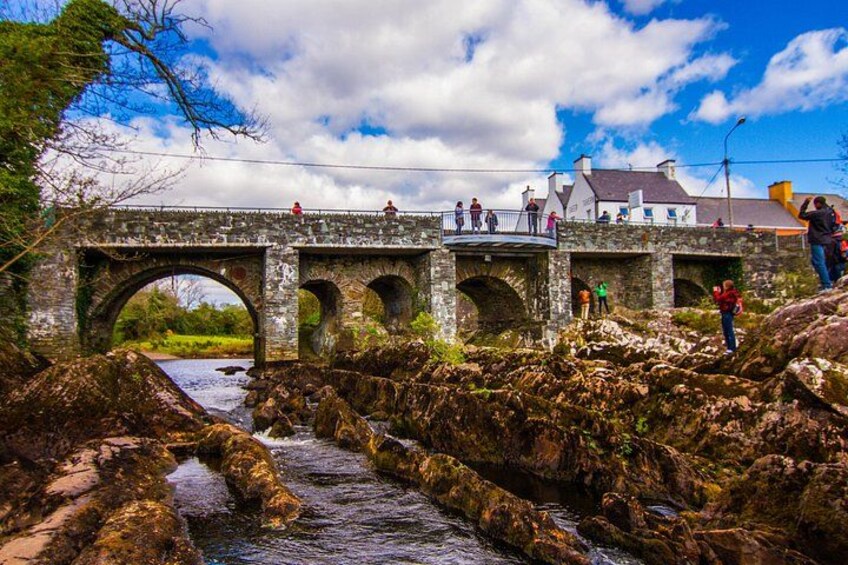 Un puente de piedra sobre un río, con gente caminando. 2
