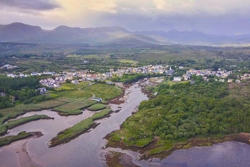 A river meandering through a town with surrounding hills and greenery. 2