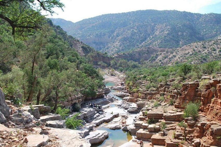 A canyon with a river, rocky terrain, and sparse vegetation. 3
