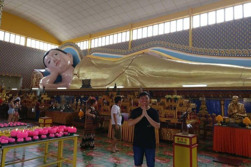 Un amplio espacio interior con un telón dorado drapeado, una estatua imponente y diversos objetos religiosos. 5
