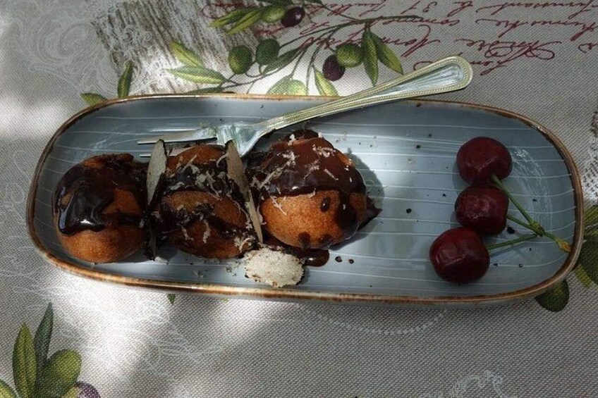 Un plato con pasteles cubiertos de chocolate y cerezas. 2