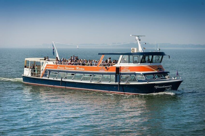 A ferry with passengers, moving on a body of water. 1