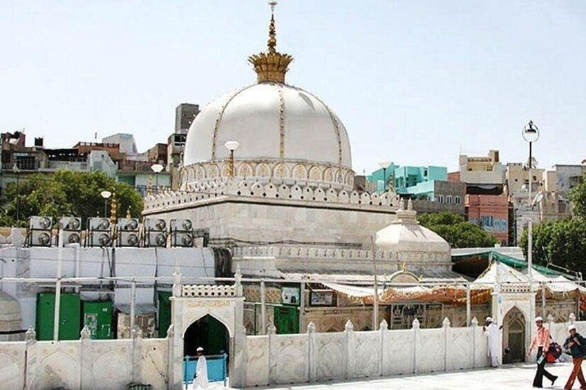 A large white dome with gold accents, surrounded by a white wall with arched openings. 2