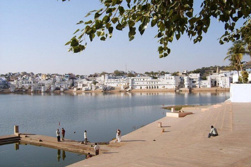 A calm waterfront with people walking and sitting along the dock. 5