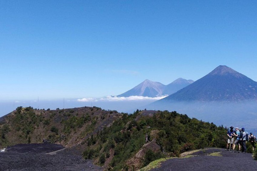 Un paisaje volcánico con un grupo de excursionistas en un sendero. 1