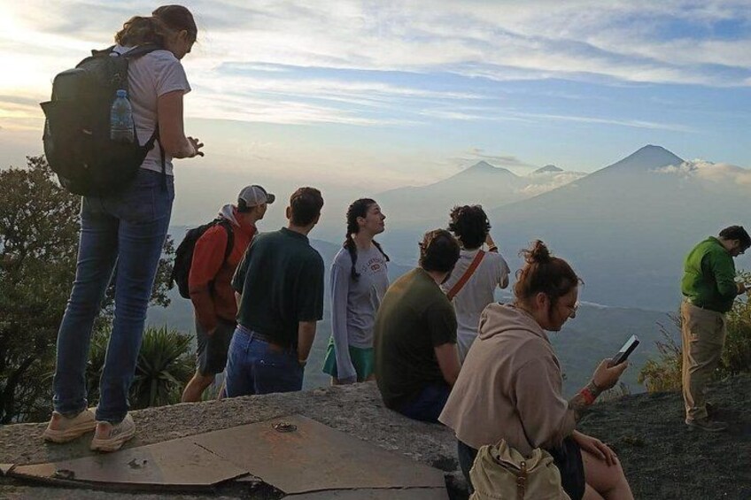 Un grupo de personas en una montaña con vista a un volcán. 2