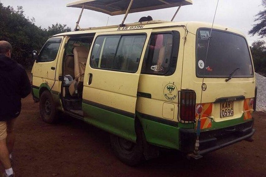 A yellow and green van parked on a dirt road with a person standing beside it. 3