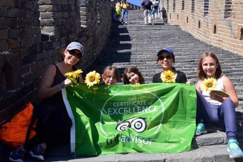 Un groupe de personnes est assis sur des marches de pierre et tient un certificat vert attestant de leur excellence. 2