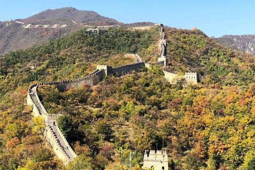 La Gran Muralla China serpenteando a través de un paisaje montañoso con follaje otoñal. 4