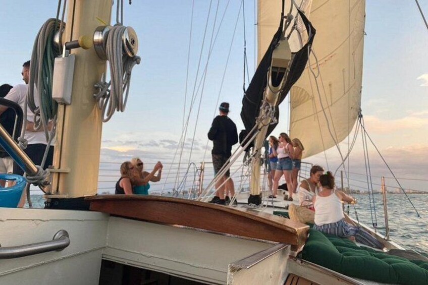 Een zeilboot met mensen aan dek, een mast en lijnen. 4