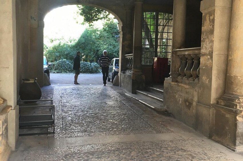 An arched stone entrance with a cobblestone path leading through it. 2