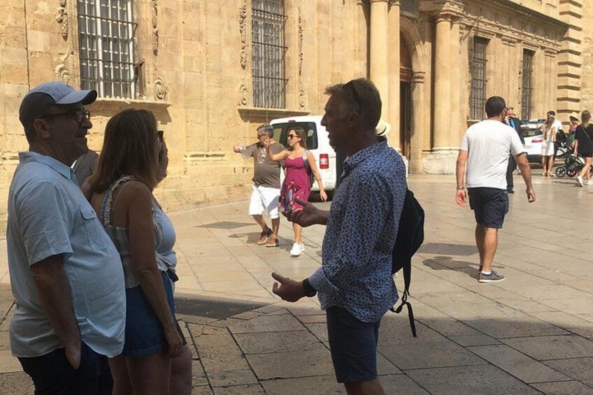 A group of people standing in a plaza with a historic building in the background. 3