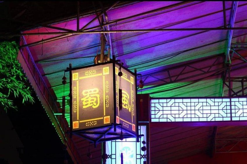 Een hanglamp met Chinese karakters, een houten plafond en een decoratieve wand. 2
