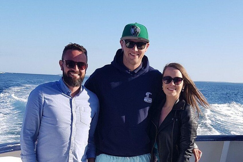 Three people on a boat with the ocean in the background. 3