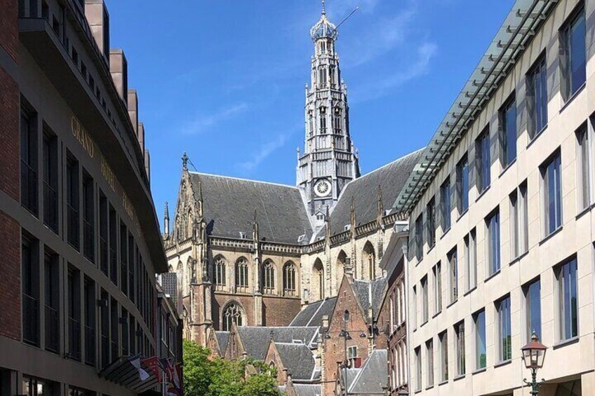 Un edificio histórico con una torre de reloj, rodeado de edificios modernos. 5