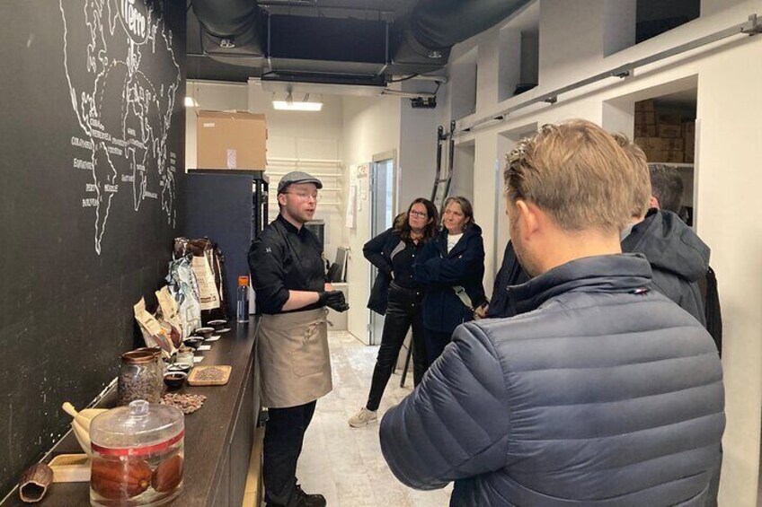 A person standing at a counter with various food items and a map on the wall. 5