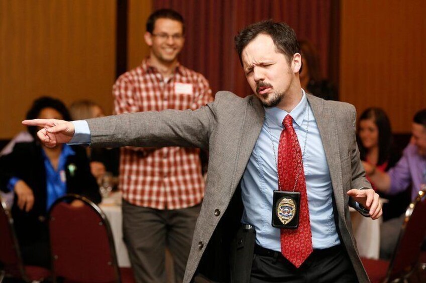 A person in a gray suit pointing to the left. 1