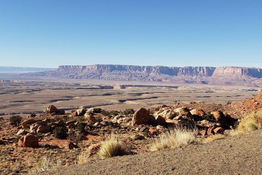 A desert landscape with rocky terrain and distant mountain ranges. 4